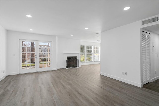 unfurnished living room featuring wood-type flooring and french doors