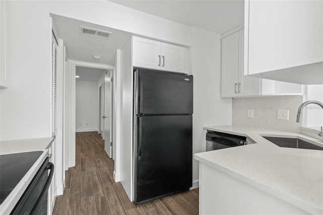 kitchen featuring sink, black fridge, dark hardwood / wood-style flooring, dishwasher, and white cabinets