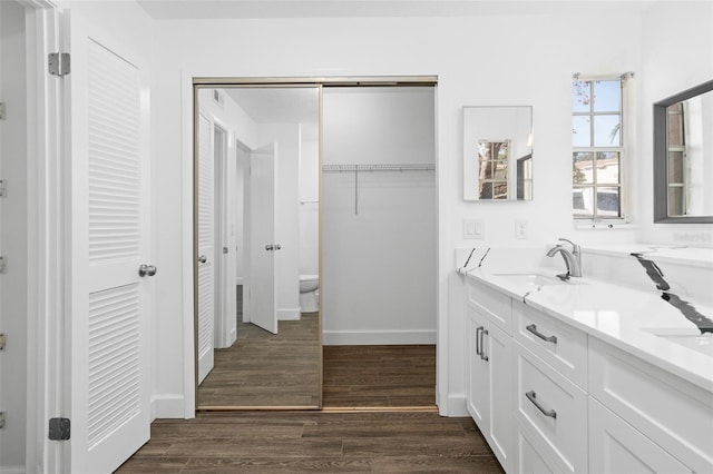 bathroom with hardwood / wood-style flooring, vanity, and toilet