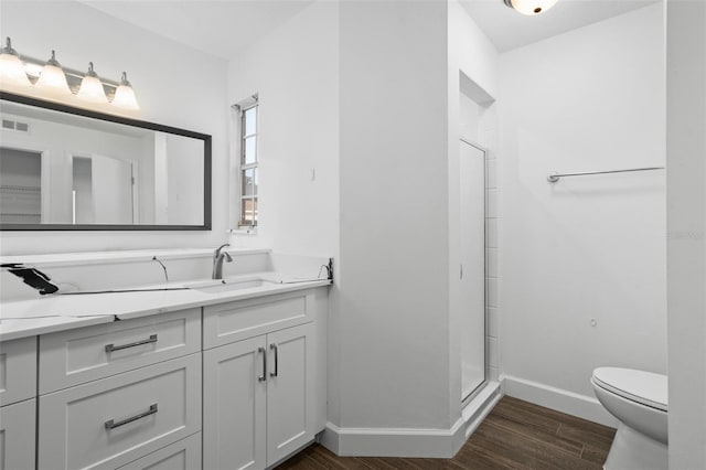 bathroom with vanity, hardwood / wood-style flooring, toilet, and walk in shower