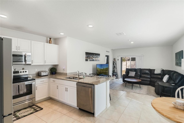 kitchen with white cabinetry, appliances with stainless steel finishes, sink, and kitchen peninsula