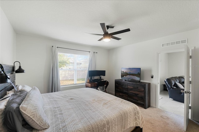 carpeted bedroom with ceiling fan and a textured ceiling