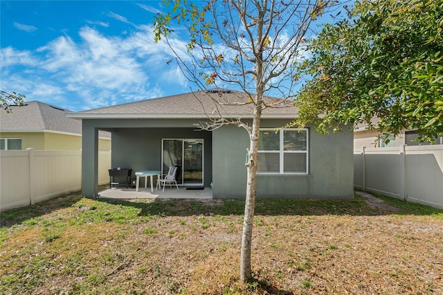 back of property with a patio area and a lawn