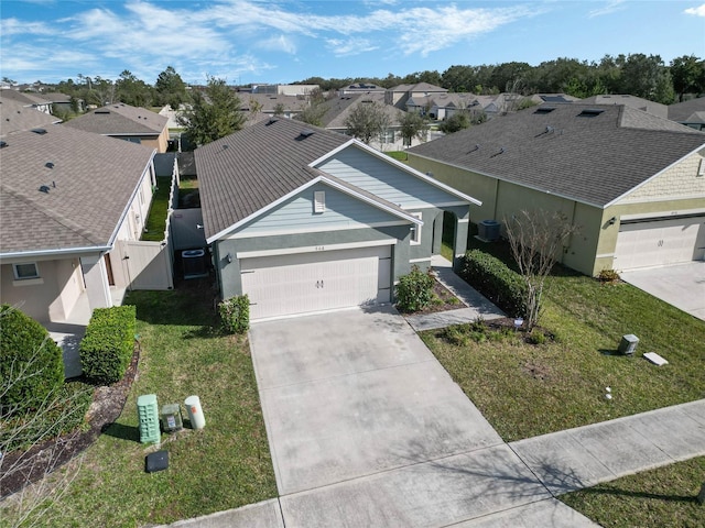 view of front facade featuring a garage, central AC unit, and a front lawn