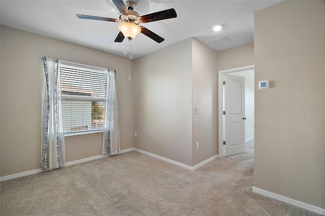 carpeted empty room with ceiling fan and a textured ceiling