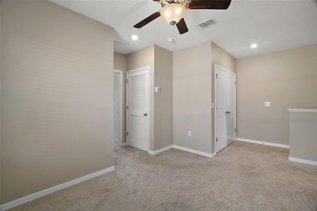 empty room featuring light colored carpet and ceiling fan