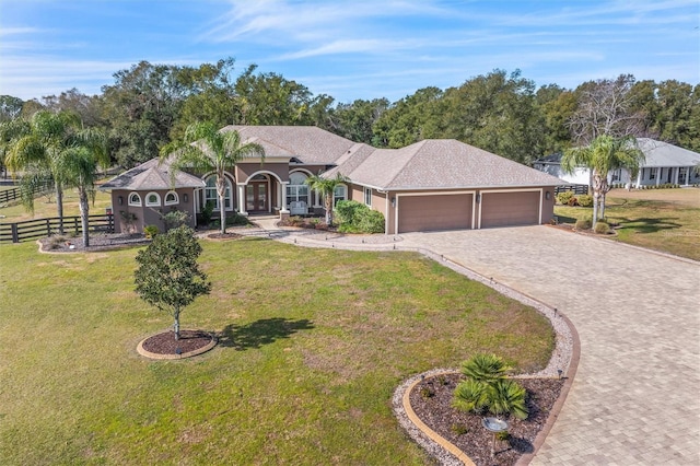 single story home featuring a garage and a front yard