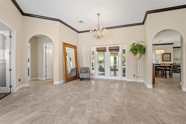 foyer featuring french doors, crown molding, and an inviting chandelier