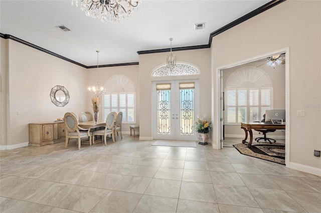 tiled foyer entrance with an inviting chandelier, ornamental molding, french doors, and a healthy amount of sunlight