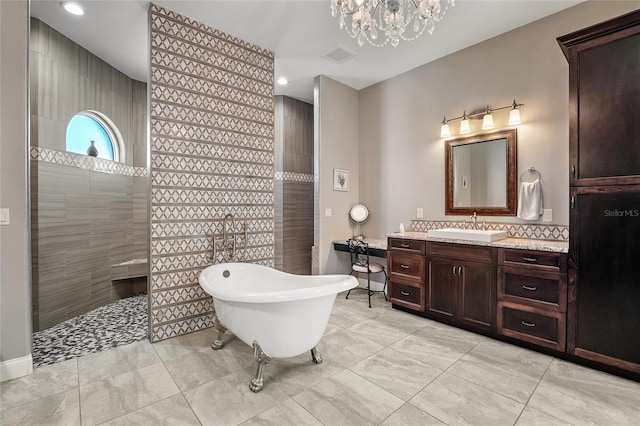 bathroom featuring shower with separate bathtub, vanity, and a chandelier