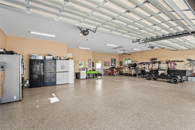 garage with stainless steel refrigerator, a garage door opener, and electric panel