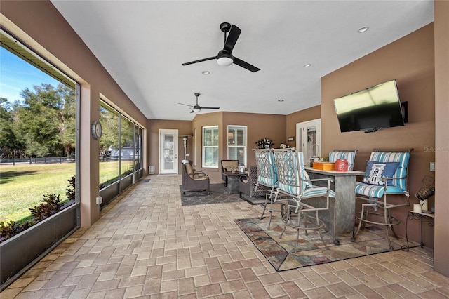 sunroom / solarium with ceiling fan and vaulted ceiling