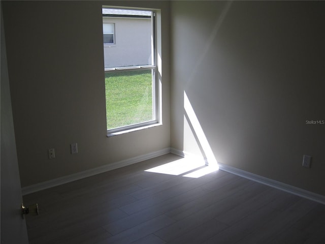 unfurnished room with baseboards and wood finished floors