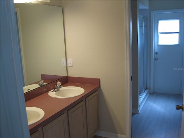 bathroom with double vanity, a stall shower, and a sink