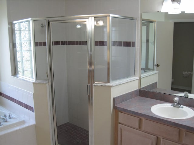 full bathroom featuring a garden tub, vanity, a shower stall, and toilet