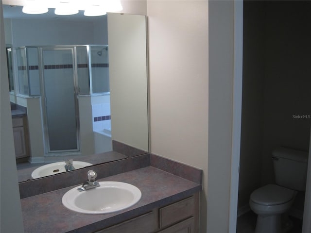 bathroom with a stall shower, vanity, and toilet