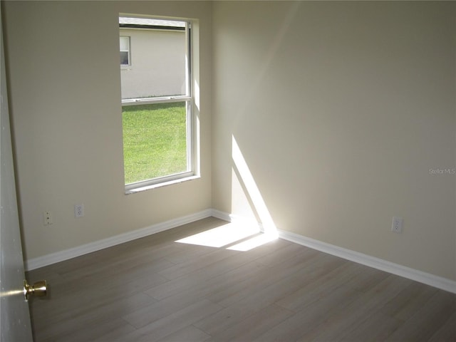 empty room with baseboards and wood finished floors