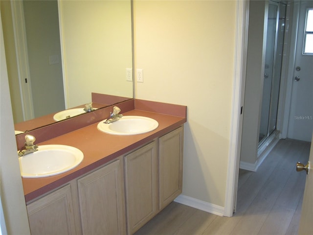 bathroom featuring double vanity, a sink, and wood finished floors