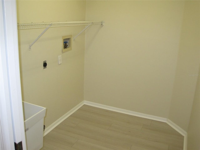 laundry area with laundry area, light wood finished floors, baseboards, hookup for a washing machine, and hookup for an electric dryer