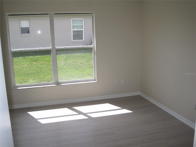 unfurnished room with baseboards and wood finished floors