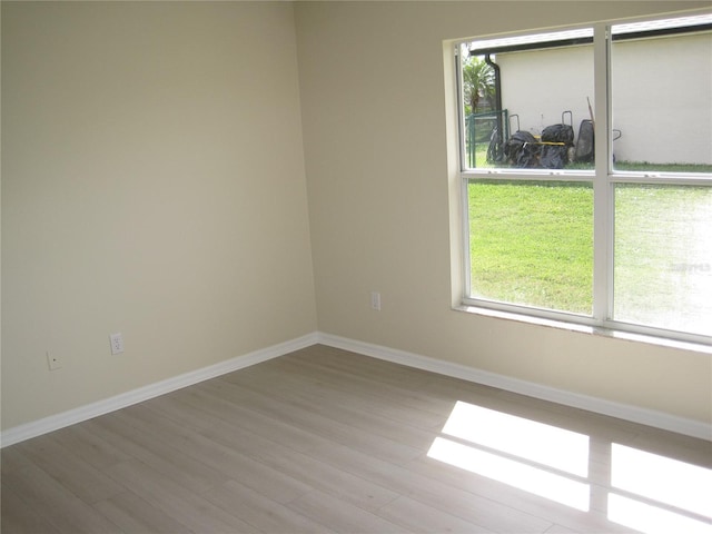 spare room featuring wood finished floors and baseboards