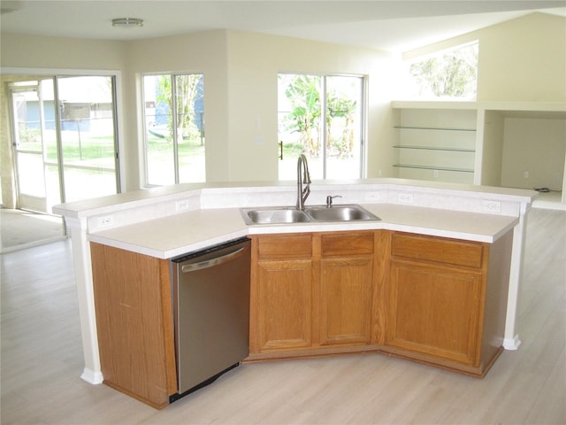 kitchen featuring a sink, light wood-style flooring, light countertops, and dishwasher