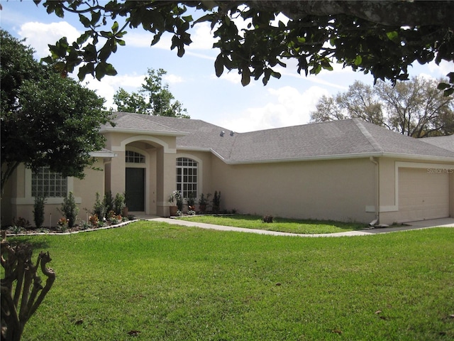 ranch-style house featuring a shingled roof, an attached garage, a front lawn, and stucco siding