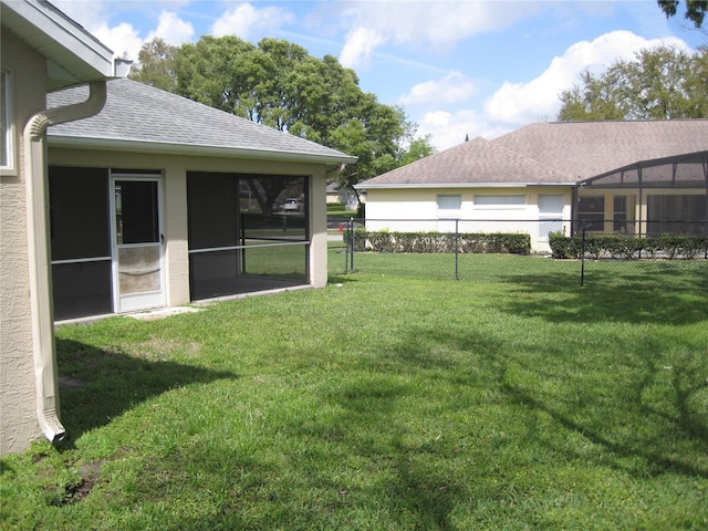 view of yard featuring a sunroom and fence