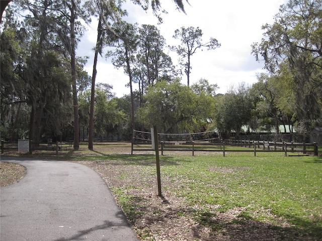 view of property's community with volleyball court and a yard