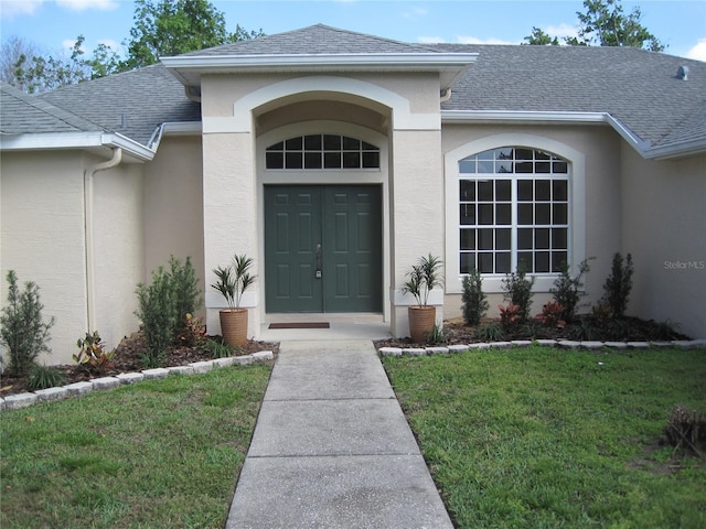 doorway to property with a shingled roof and stucco siding