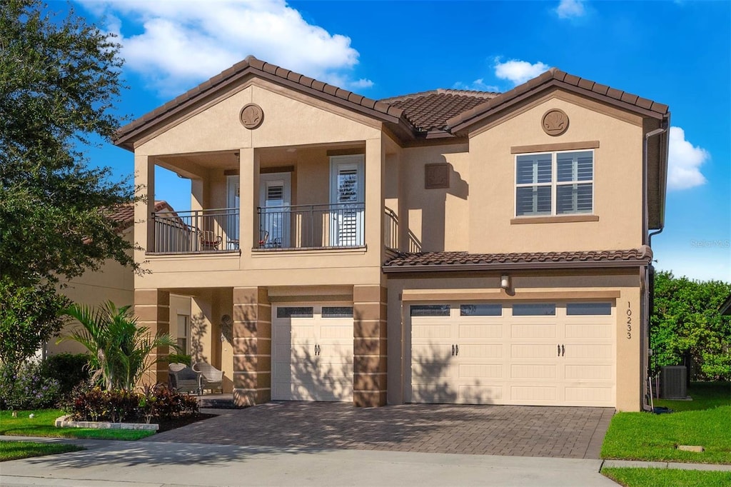 mediterranean / spanish home with a garage, a balcony, and central AC