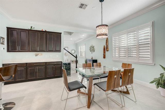 tiled dining area featuring ornamental molding and wine cooler