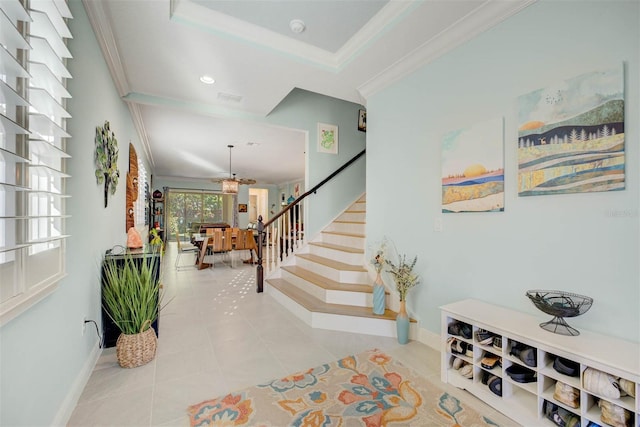 foyer entrance featuring light tile patterned floors and ornamental molding