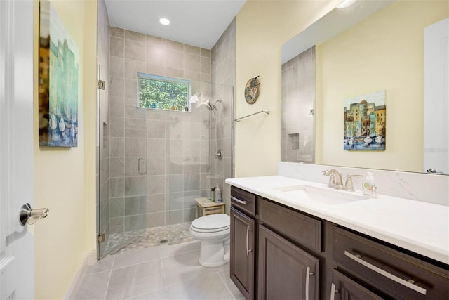 bathroom with a shower with door, vanity, tile patterned floors, and toilet