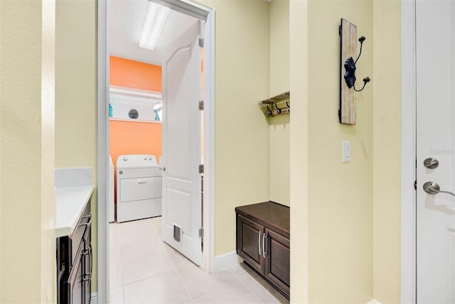 corridor featuring washing machine and dryer and light tile patterned floors