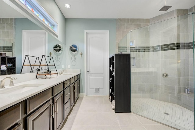 bathroom featuring vanity, tile patterned flooring, and a tile shower