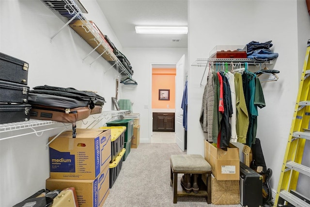 walk in closet featuring light colored carpet