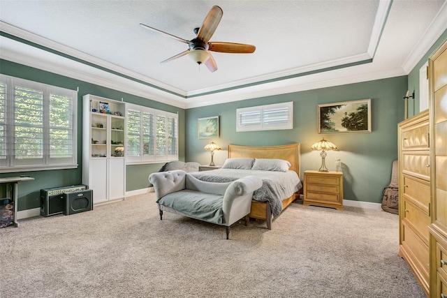 carpeted bedroom with crown molding, ceiling fan, and a raised ceiling