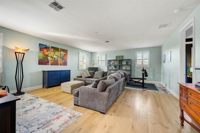 living room featuring light hardwood / wood-style floors and a textured ceiling