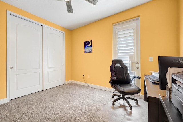 carpeted office space featuring ceiling fan