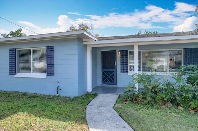 entrance to property with a lawn