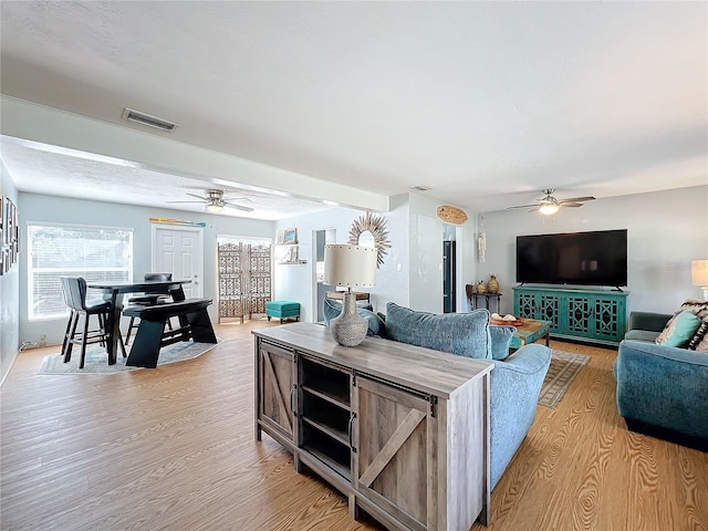 living room featuring ceiling fan and light hardwood / wood-style flooring