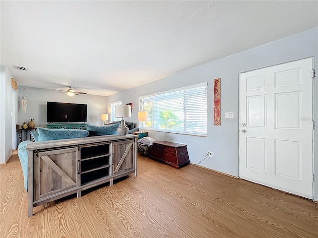 living room with ceiling fan and light hardwood / wood-style flooring