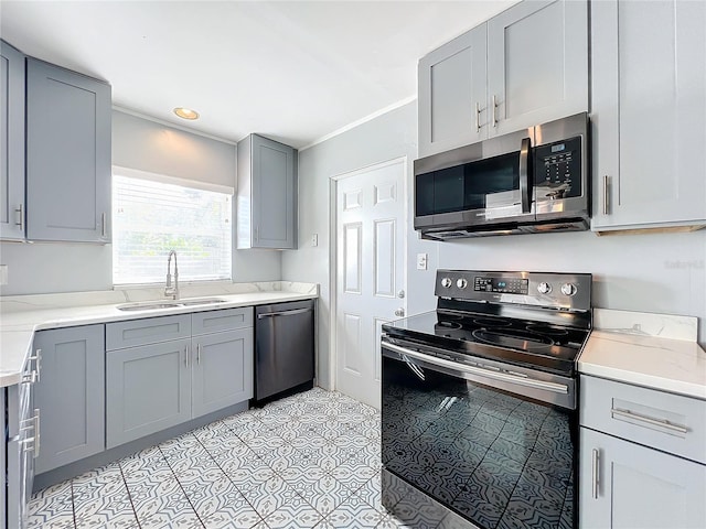 kitchen featuring crown molding, stainless steel appliances, gray cabinets, and sink