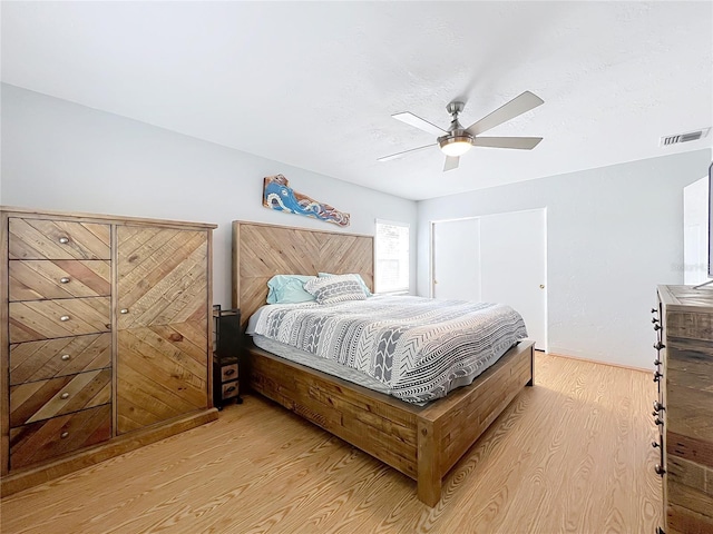 bedroom featuring ceiling fan, a closet, and light wood-type flooring