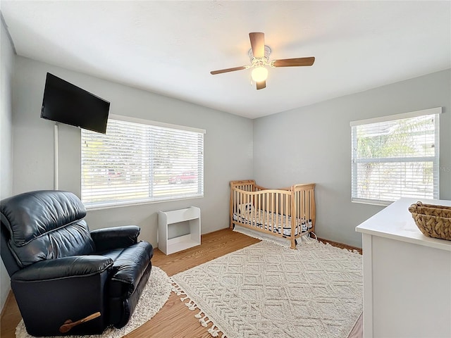 bedroom with multiple windows, light hardwood / wood-style flooring, and ceiling fan