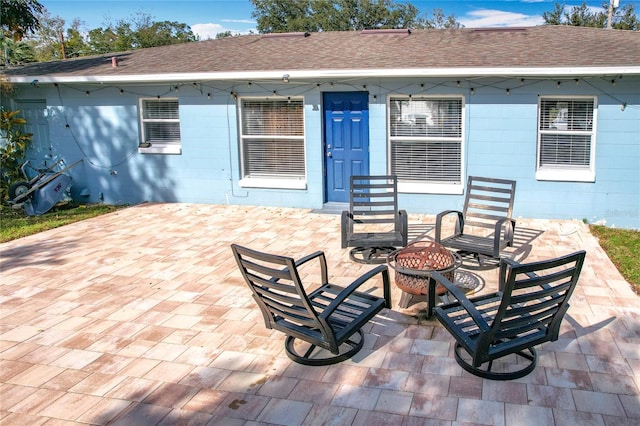 back of property featuring a patio area and a fire pit