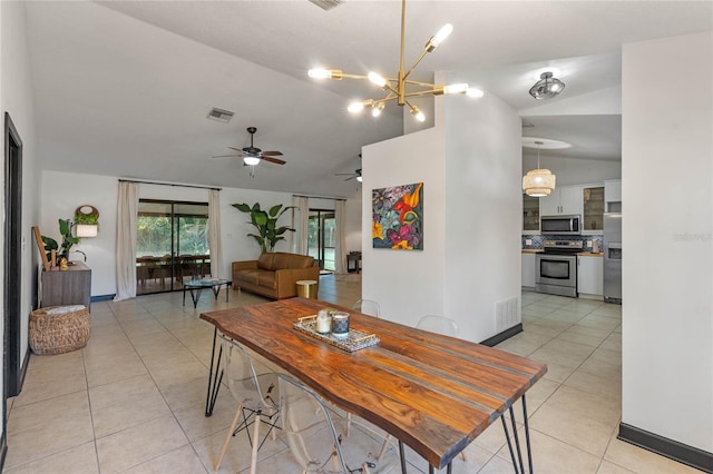 tiled dining room featuring lofted ceiling and a chandelier