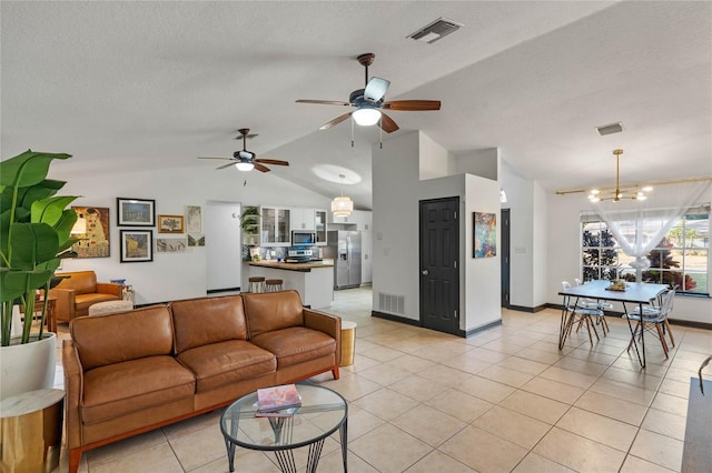 tiled living room with lofted ceiling, ceiling fan with notable chandelier, and a textured ceiling