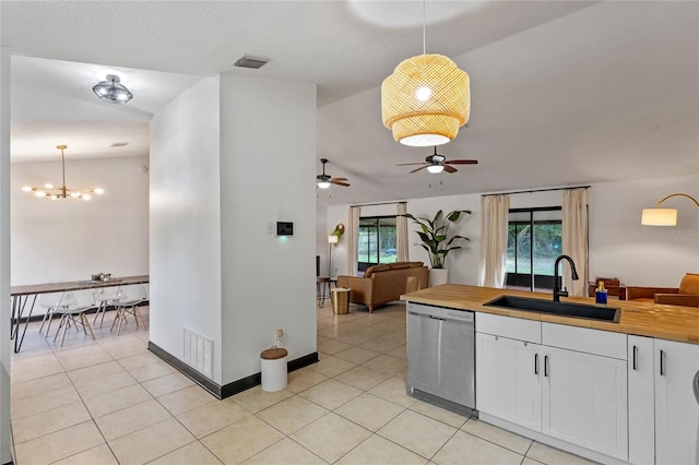 kitchen with wood counters, sink, white cabinetry, stainless steel dishwasher, and pendant lighting